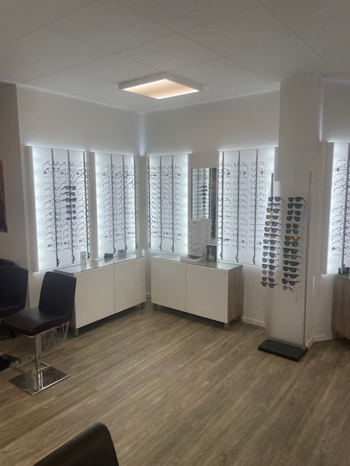 Beleuchtete Präsentationswände mit Brillenfassungen bei Augenoptik Paschhoff in Düsseldorf